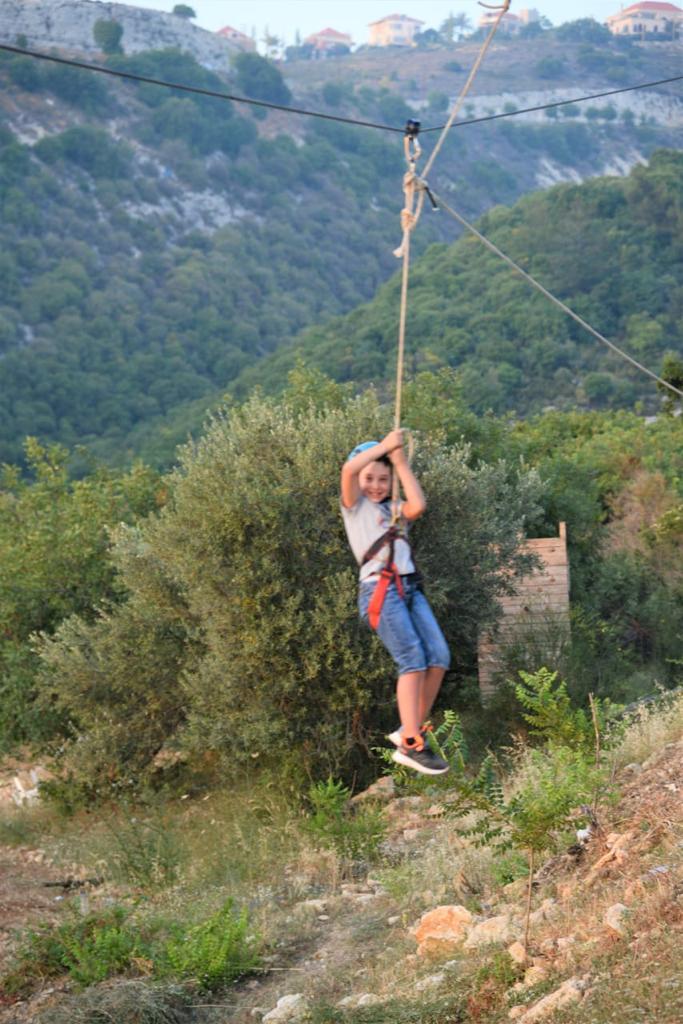 A boy on a zip line at Bmehrine | Byblos Nature | Cassia | The INN.