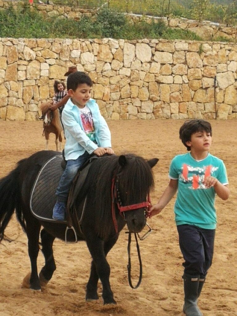 A boy riding a horse through the serene landscapes of Bmehrine | Byblos Nature | Cassia | The INN.