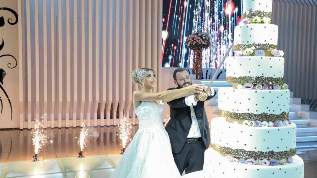 a man and woman cutting a wedding cake