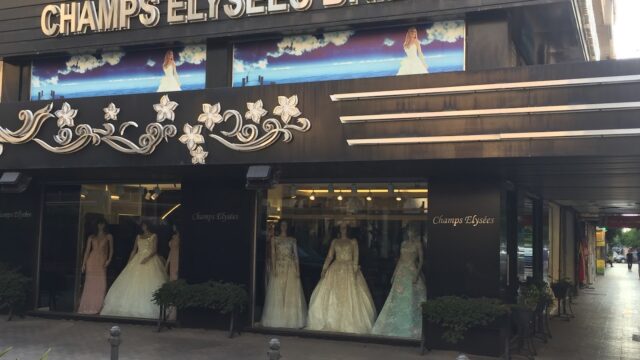 a store front with mannequins in dresses