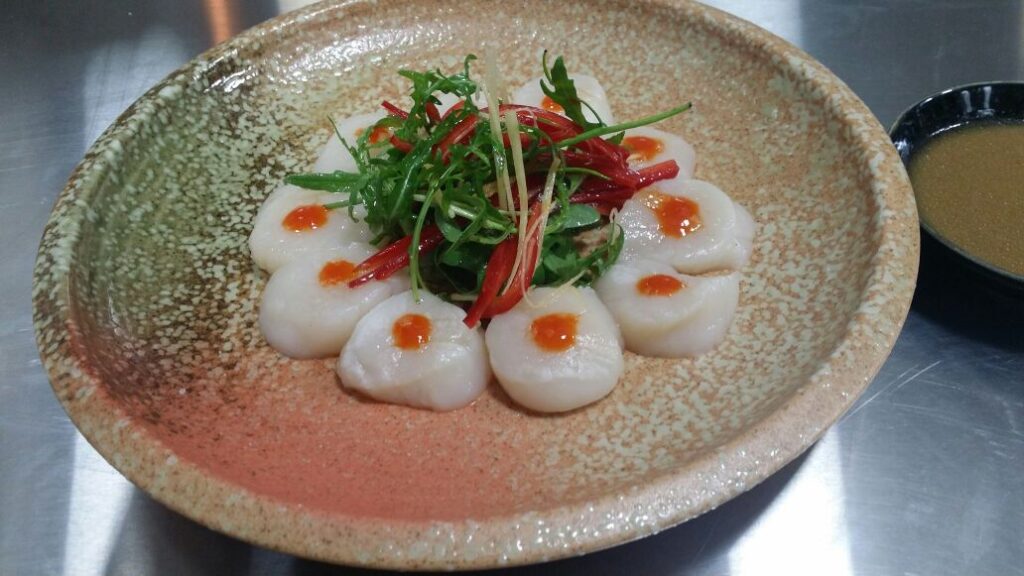 A plate of scallops and vegetables prepared by ChefXChange SAL.