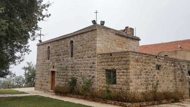 a stone building with a cross on top