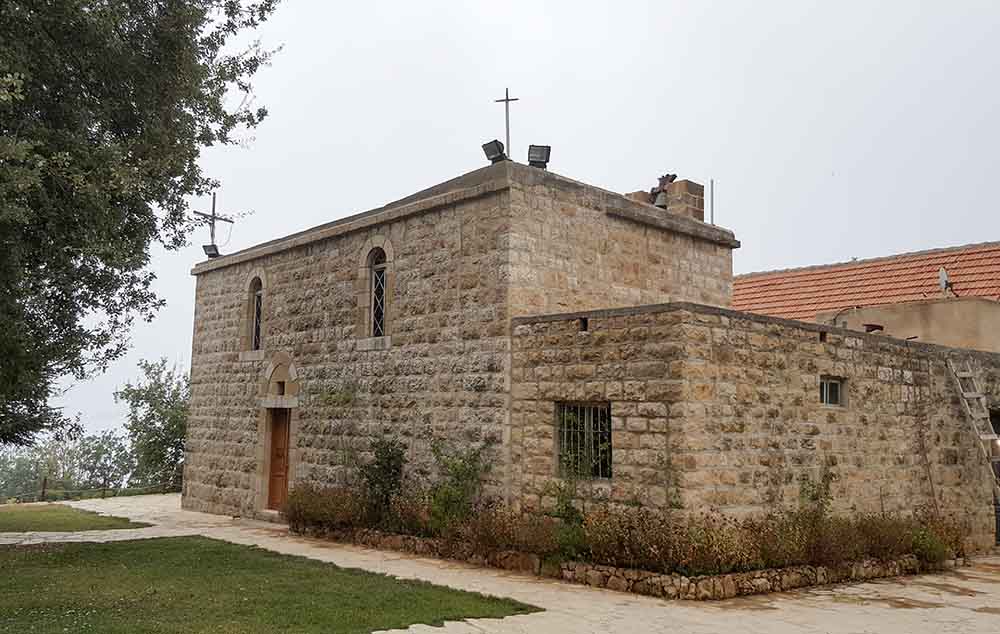 a stone building with a cross on top