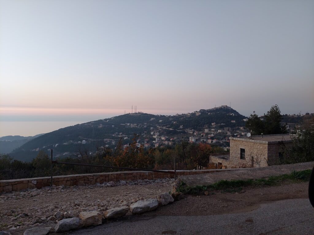 a stone building with a hill in the background