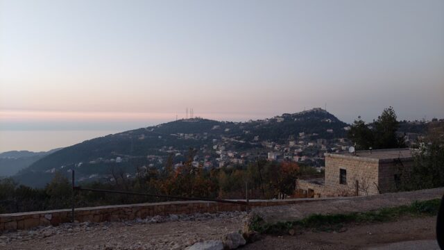 a stone building with a hill in the background