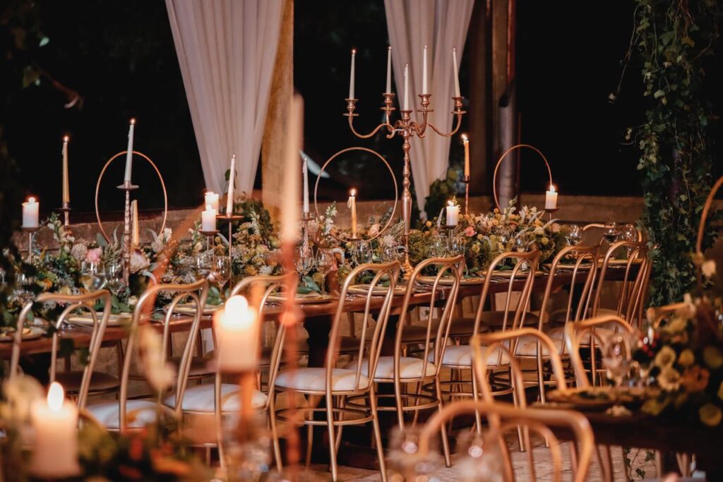 "A table set with candles and chairs by Dalia Catering."