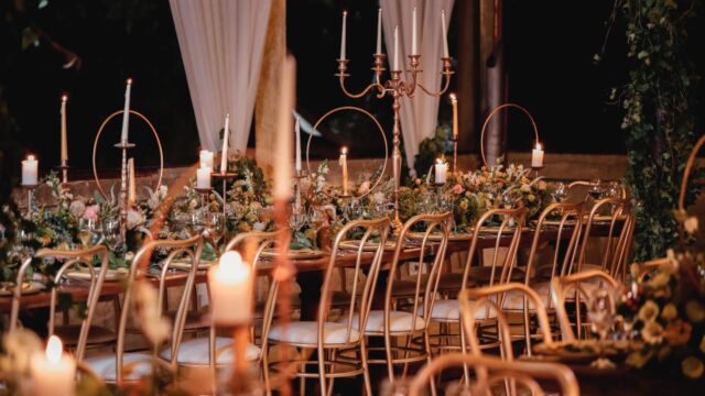 "A table set with candles and chairs by Dalia Catering."