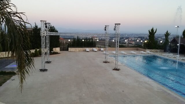 a pool with lights and a building in the background