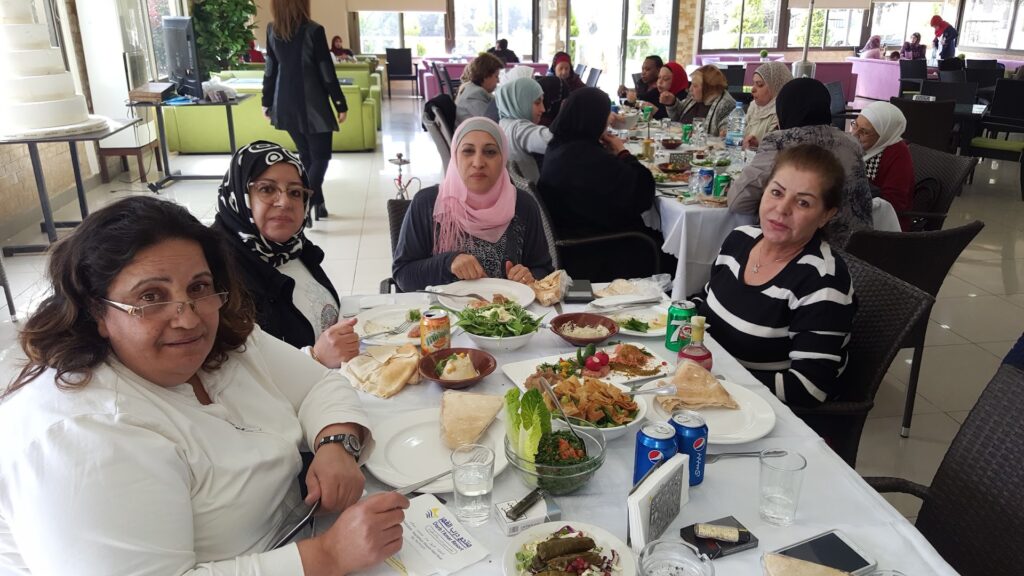 a group of women sitting at a table with food