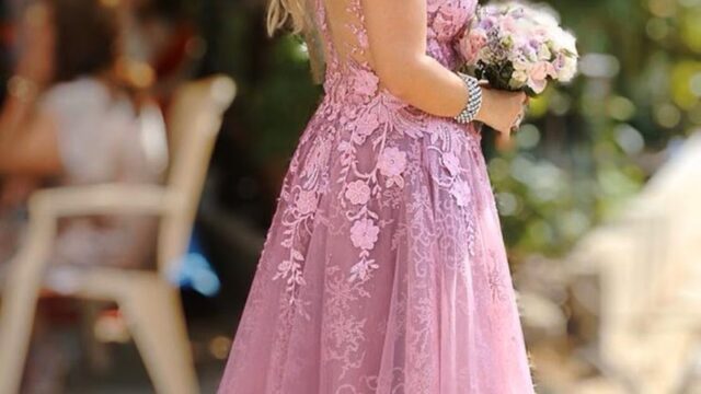 a woman in a pink dress holding a bouquet