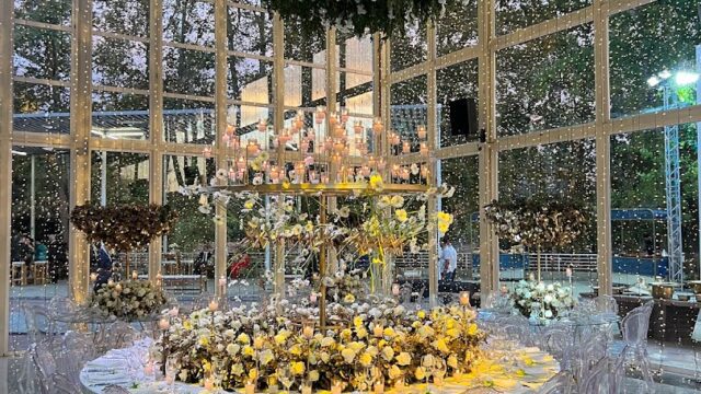 a large room with a table with flowers and chairs