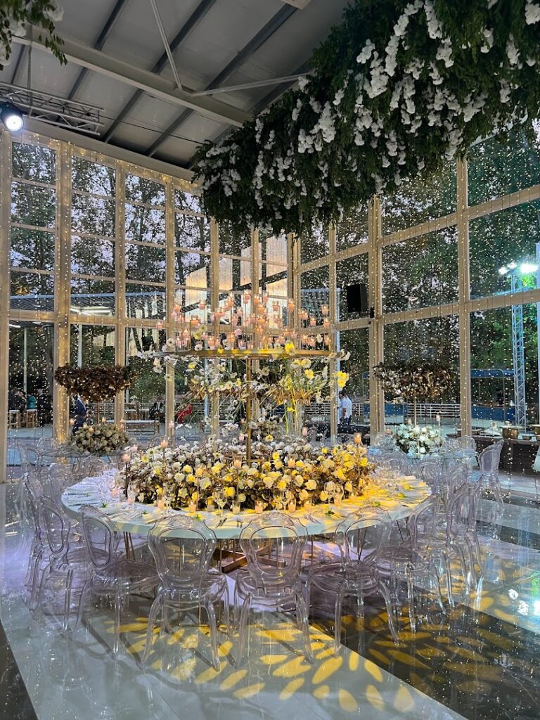 a large room with a table with flowers and chairs