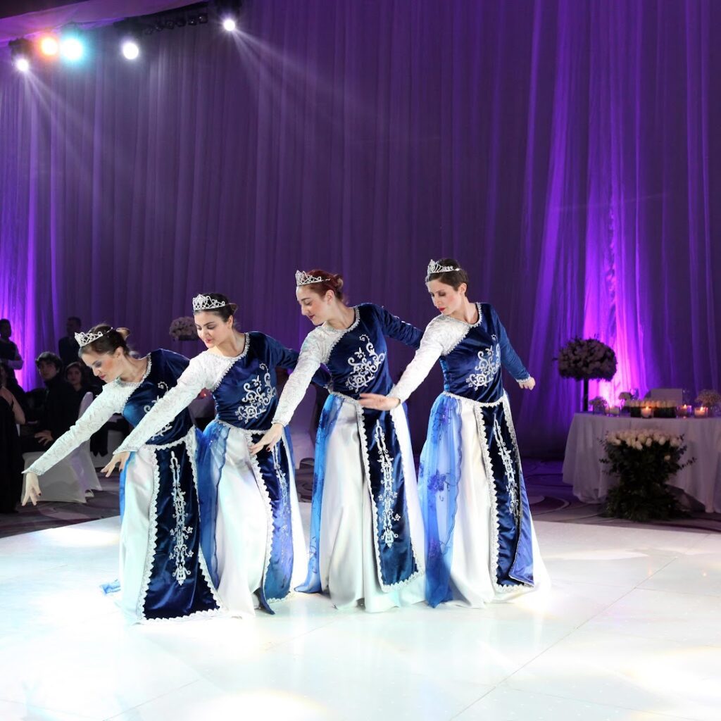 a group of women in blue dresses dancing on a stage