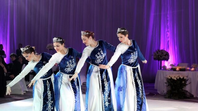 a group of women in blue dresses dancing on a stage