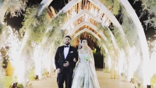 a man and woman walking under a arch with lights