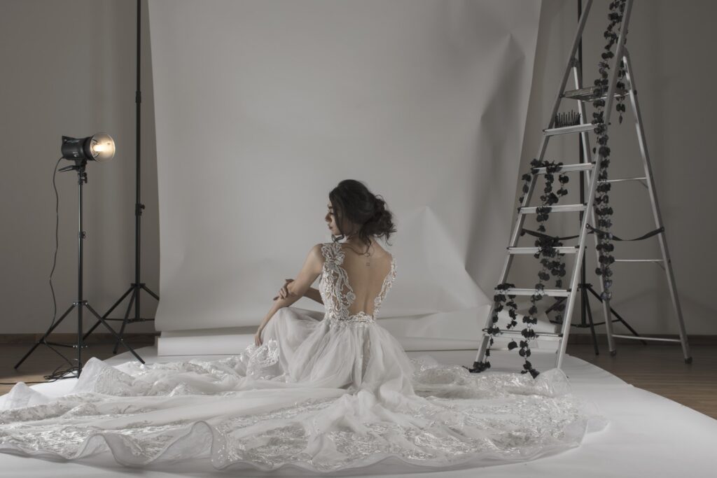 a woman in a white dress sitting in a white room