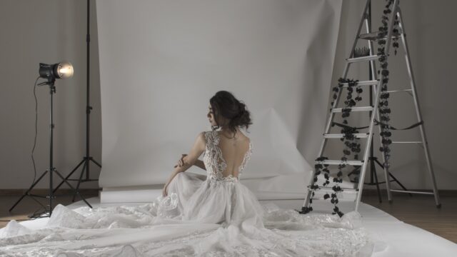 a woman in a white dress sitting in a white room