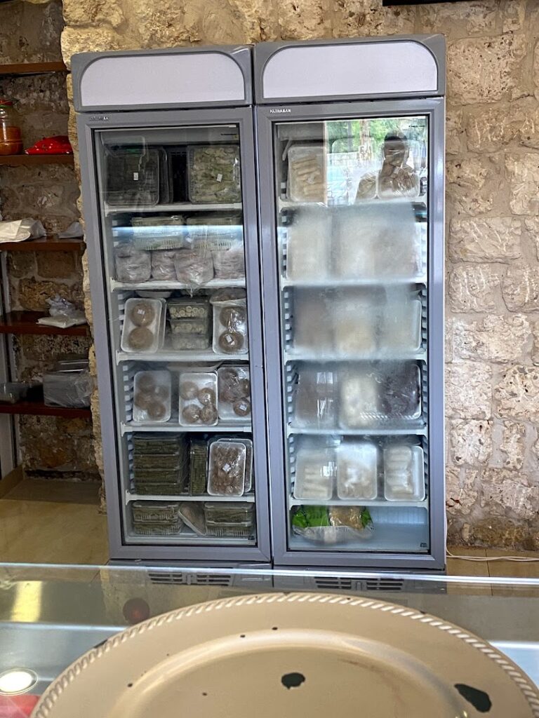 "A Khoury Kitchen refrigerator with food in it."