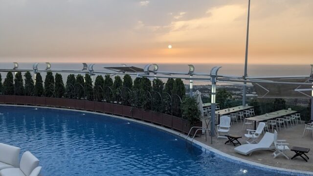 a pool with chairs and a large body of water