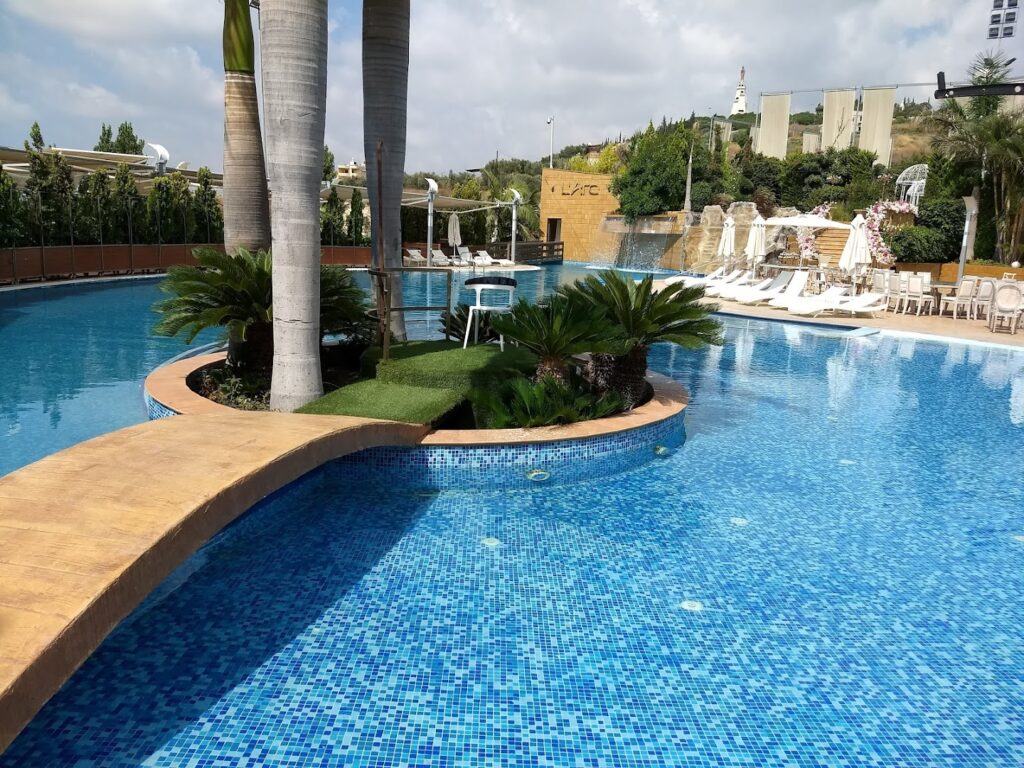 a pool with palm trees and chairs