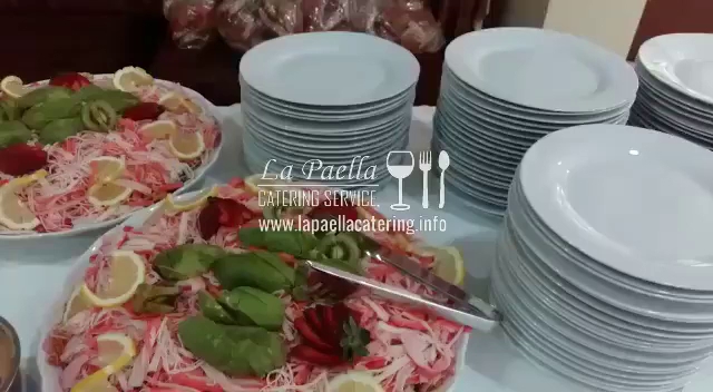 La Paella Catering serves a stack of plates and a plate of food.