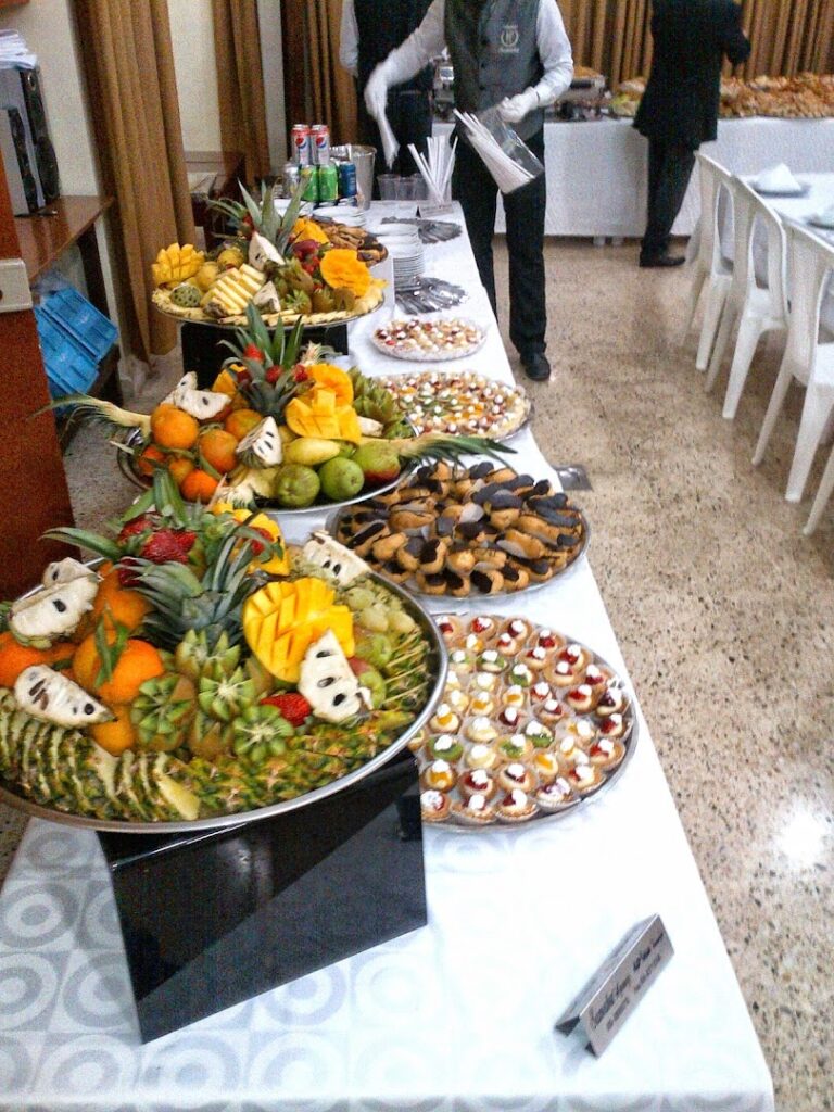 La Paella Catering presents a table full of fruit and desserts.