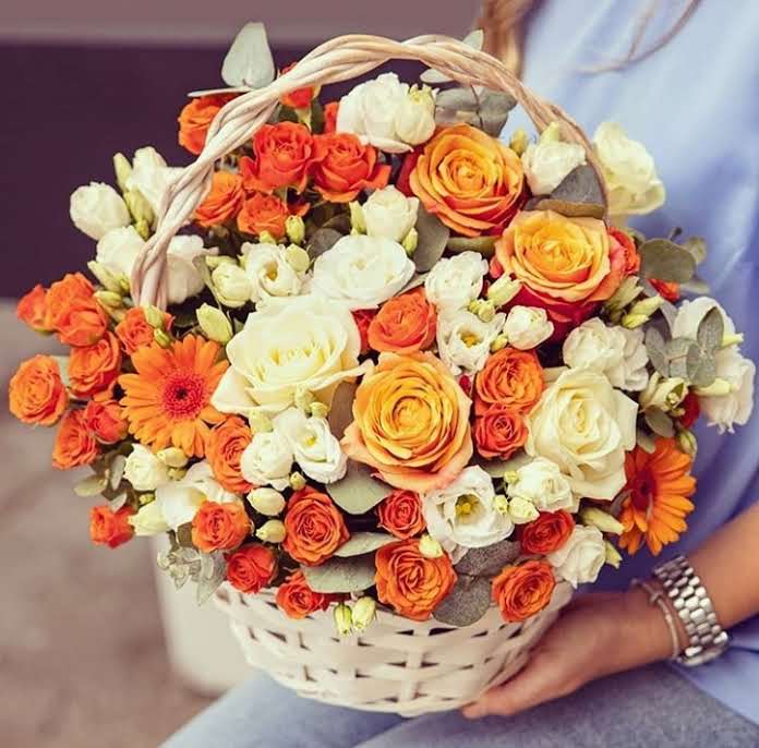 a woman holding a basket of flowers