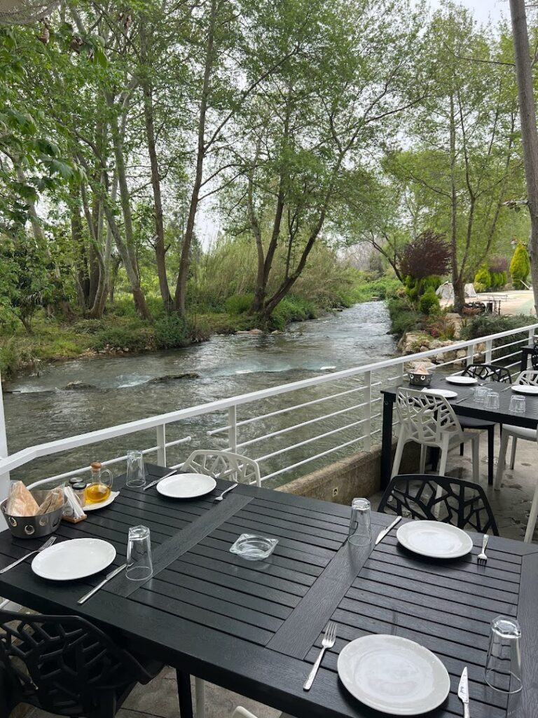 "Lilium Venue & Restaurant offers a beautiful setting with a table and chairs on a patio, providing stunning views overlooking a river."