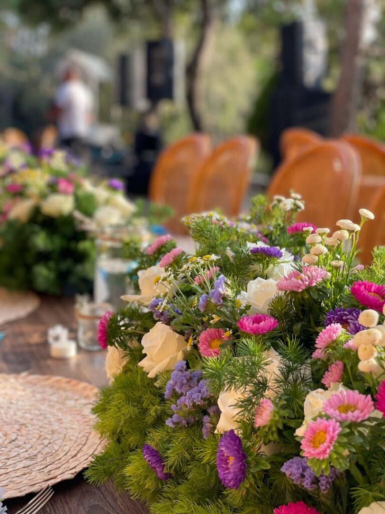 "A group of flowers on a table line events by Tima."