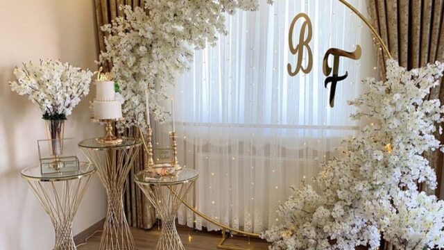A white arch with flowers, candles, and the keyword "MHeventslb."