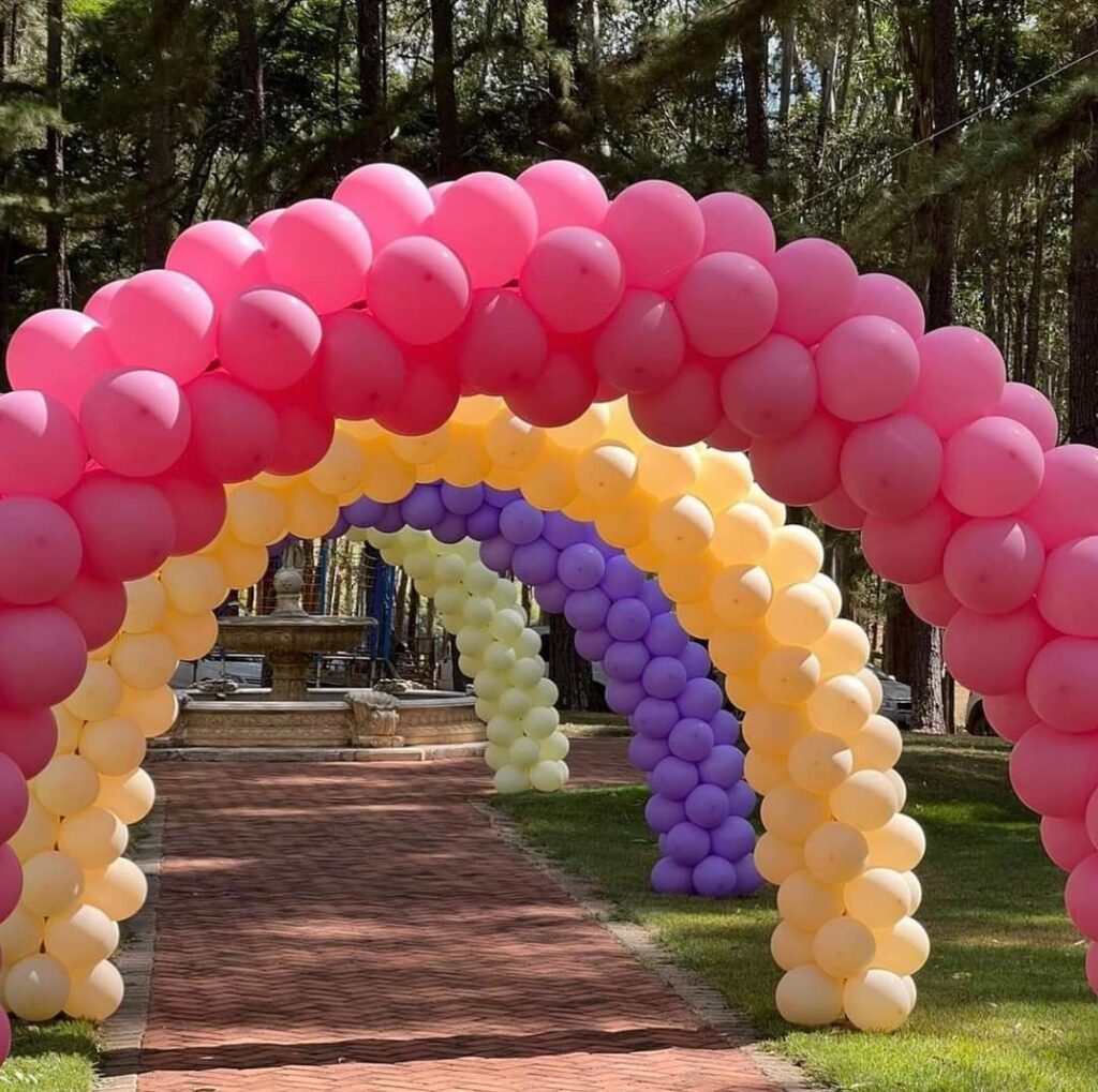 A group of balloons on a path leads to the Maison des ballons.