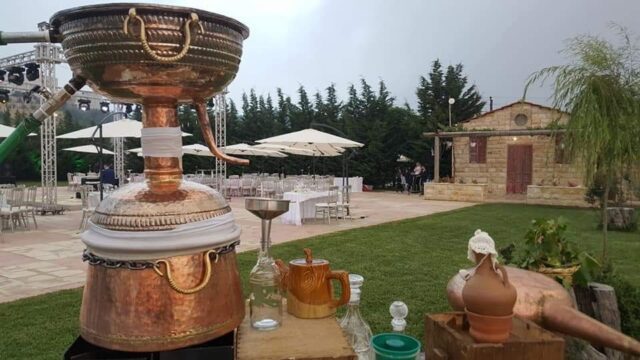 a table with a large copper pot and cups on it