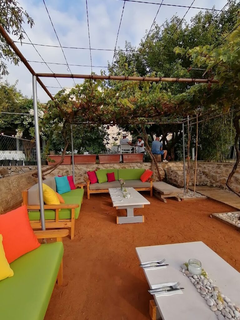 a patio area with a pergola and a table and chairs