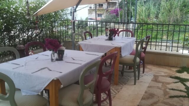 Nazira Catering provides a table and chairs under a white umbrella for your event.