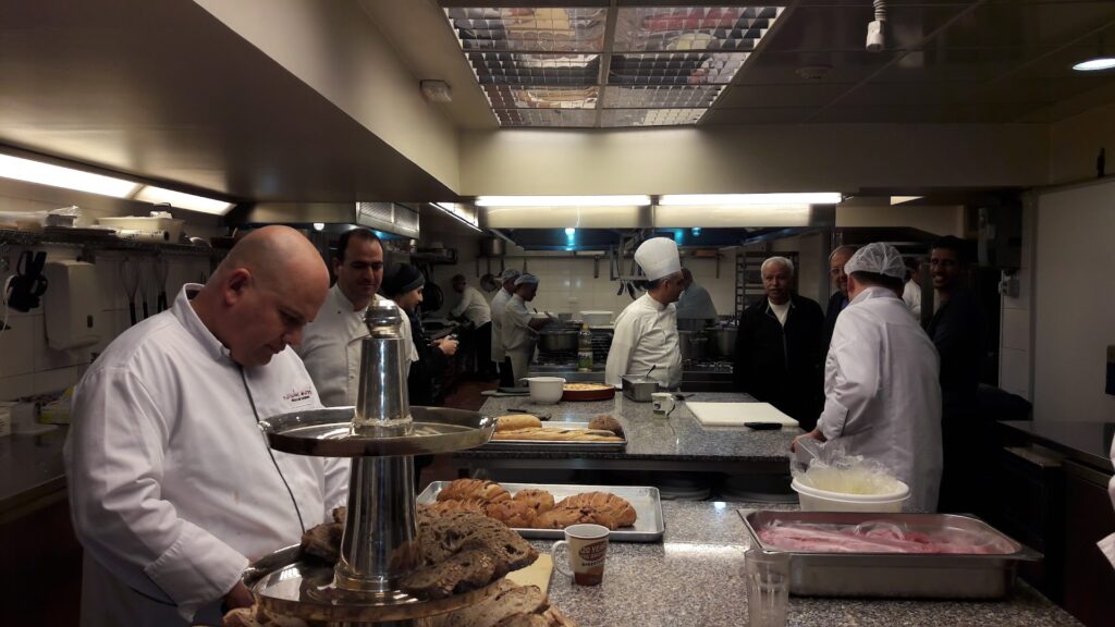 A group of people in a kitchen, including Nicolas Audi Catering SAL, prepare delicious meals for the guests.