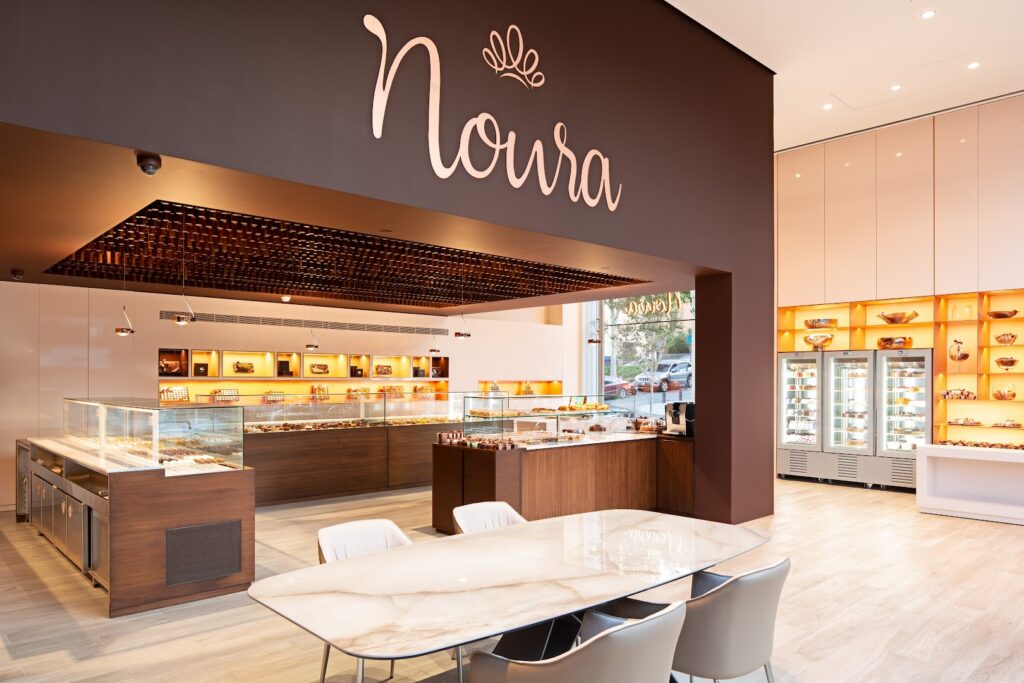 "Noura Downtown is a restaurant with a table and chairs."