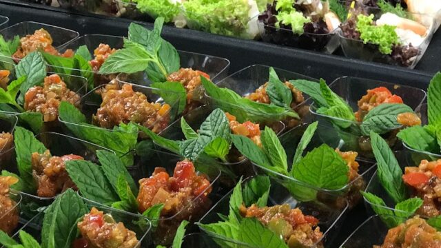 "A trays of food with leaves catered by Ostra Catering."