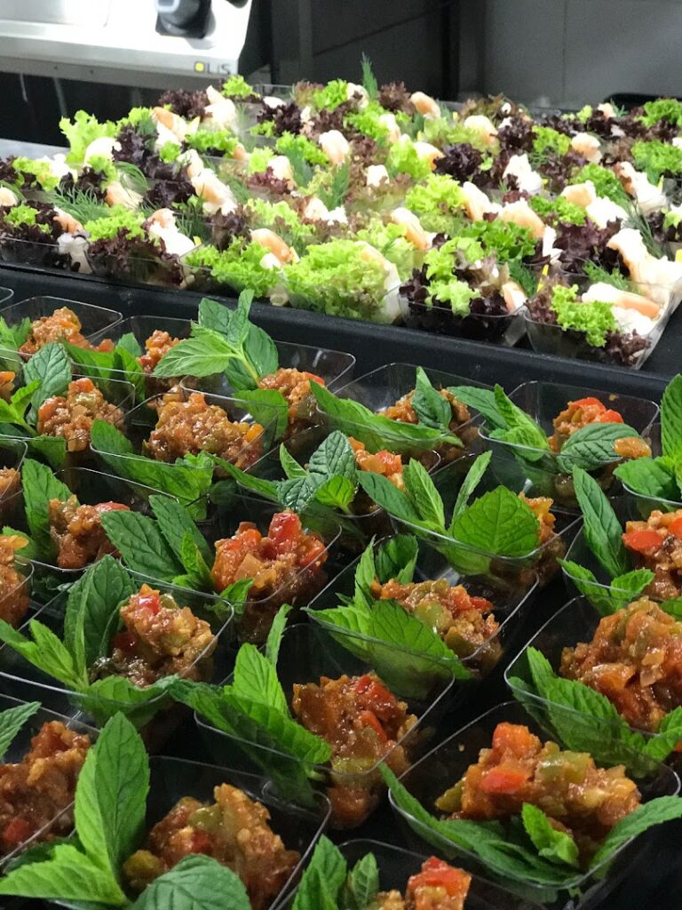 "A trays of food with leaves catered by Ostra Catering."