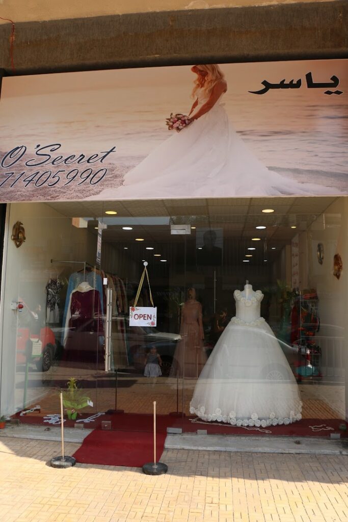 a store front with a sign and a dress on it