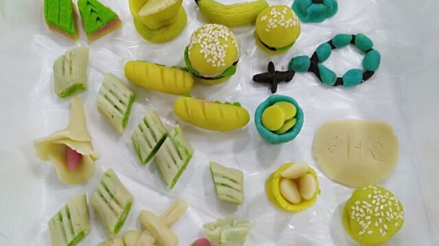 A group of colorful objects, including the keyword "Patisserie Laura," placed on a white surface.