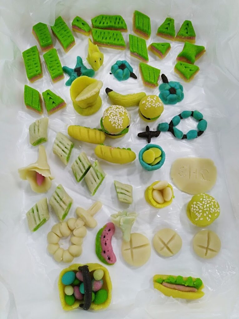 A group of colorful objects, including the keyword "Patisserie Laura," placed on a white surface.