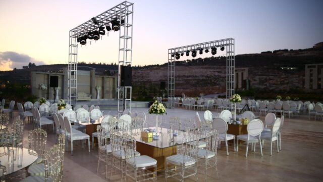 a large outdoor event setting with white chairs and tables