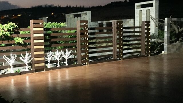 a fence and a stone wall at night