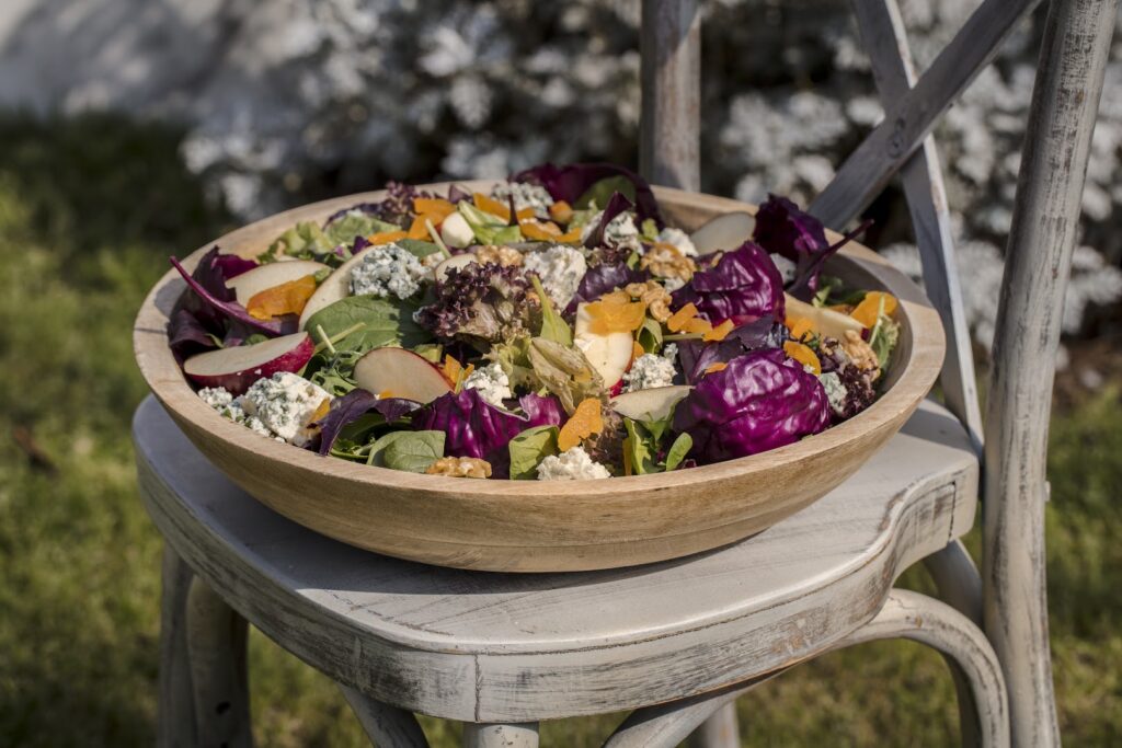 "A bowl of salad from Silverspoon Catering on a chair."