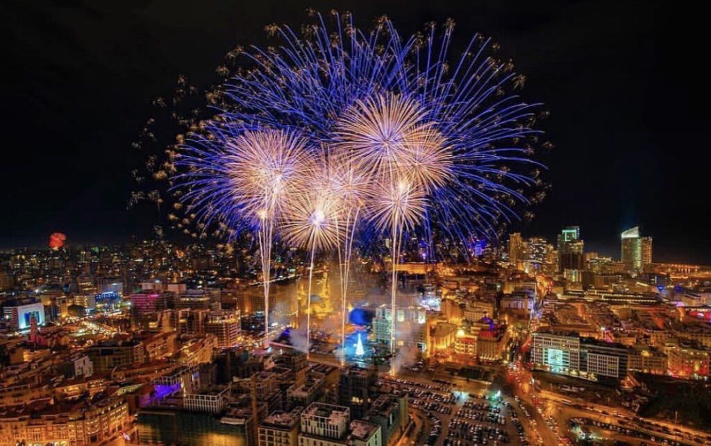"TABBARA FIREWORKS CO. presents magnificent fireworks in the sky over a city."