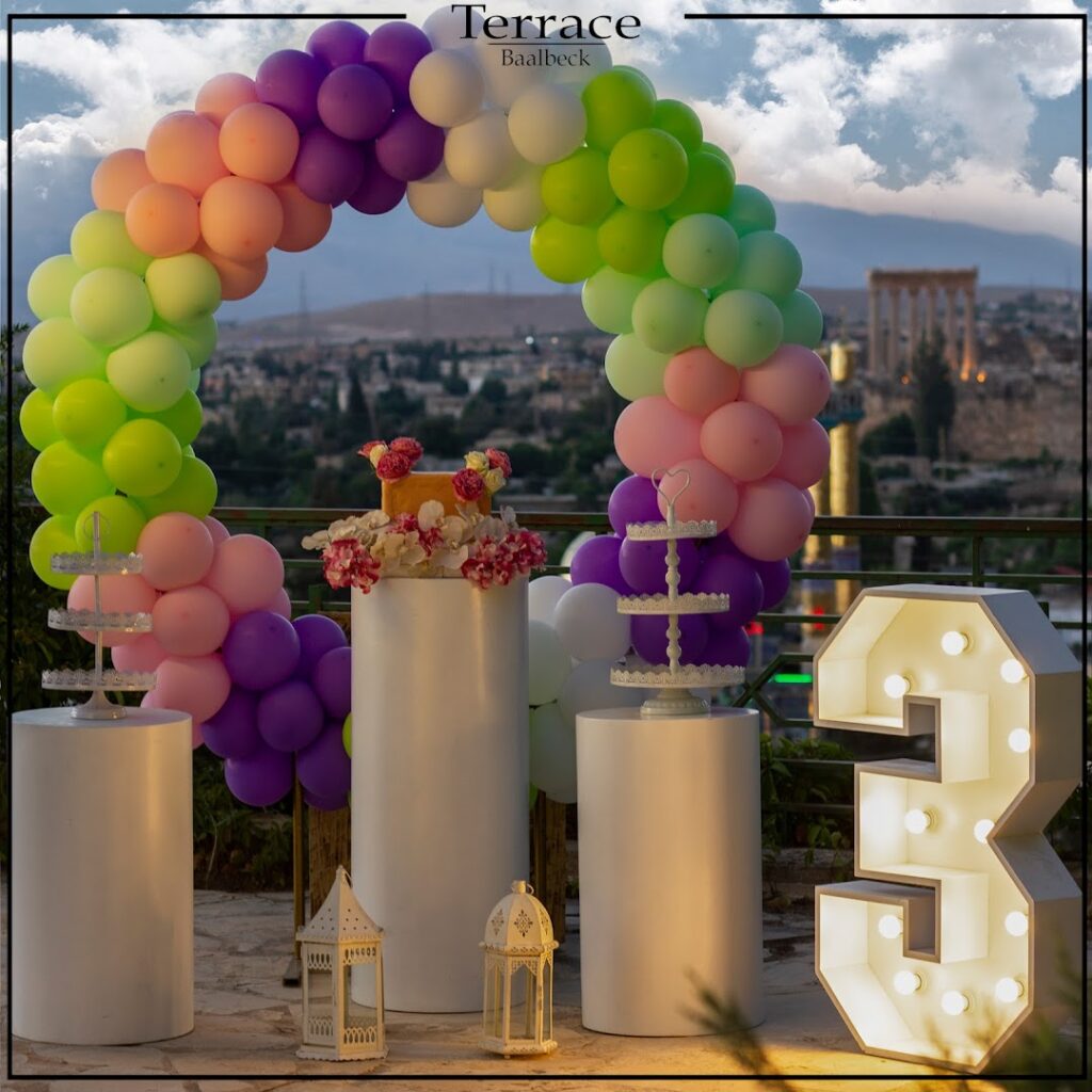 A colorful balloon arch with a large number three decorates the Terrace Baalbeck.