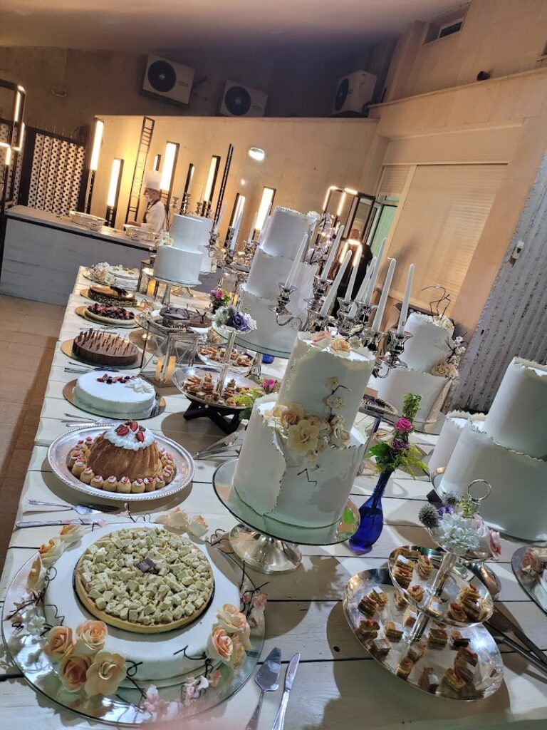 "The Catering Boutique offers a table with many cakes and desserts."
