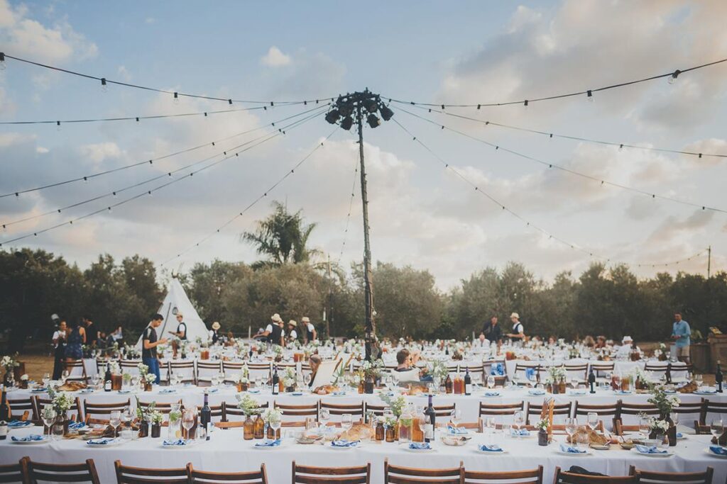 "The Eventist  hosts a large outdoor event with tables and chairs."