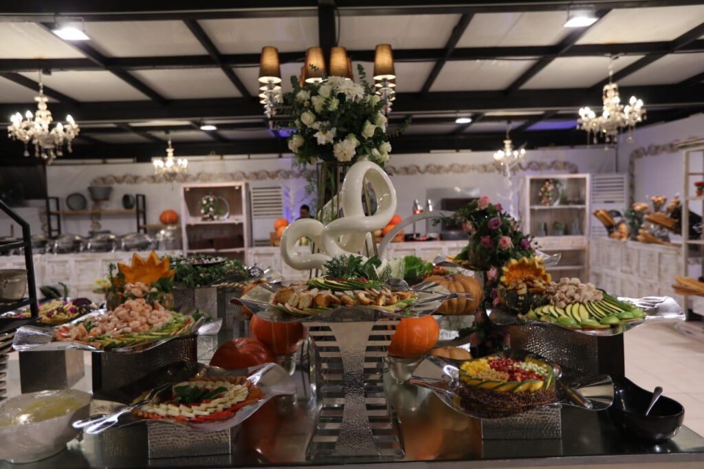 A buffet table with food on it, provided by The Experts Catering and Pastry.