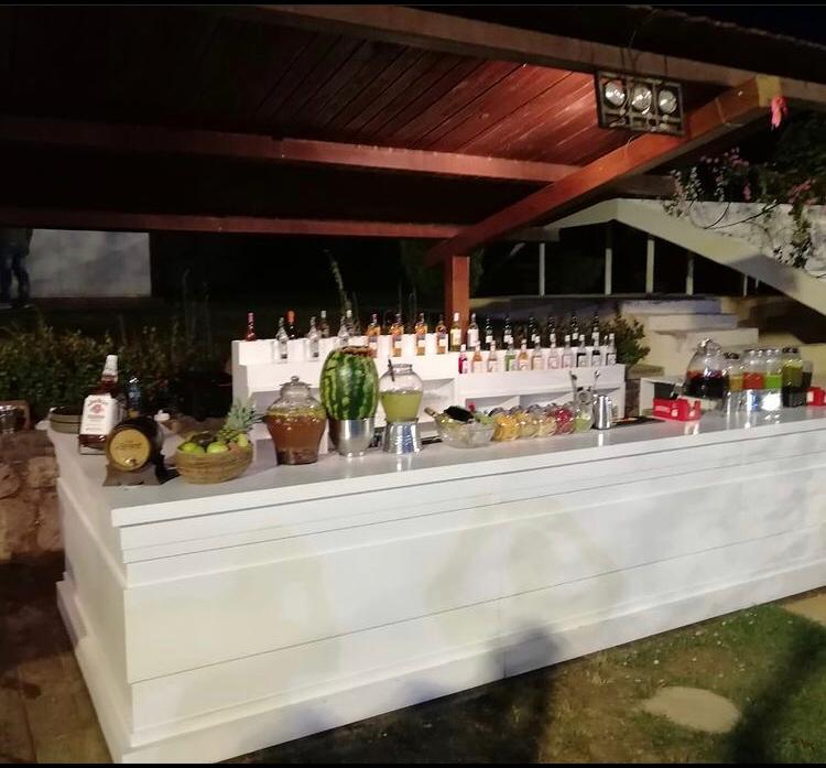 "The Barmentor Series" features a white bar adorned with bottles of alcohol and a variety of fruit on display.